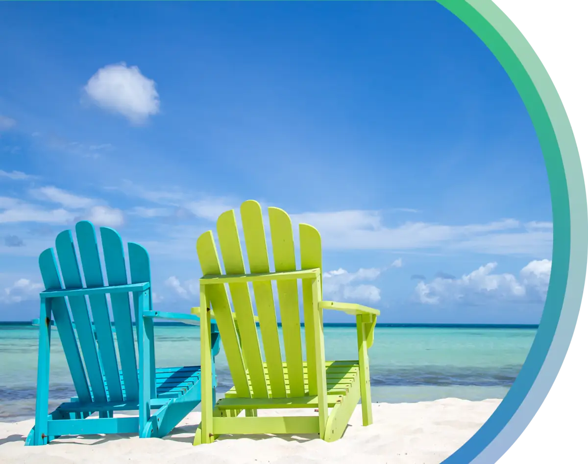 A smiling man with short dark hair, in a green shirt and white t-shirt, relaxes on a couch, talking on a phone. Bright and cheerful ambiance.